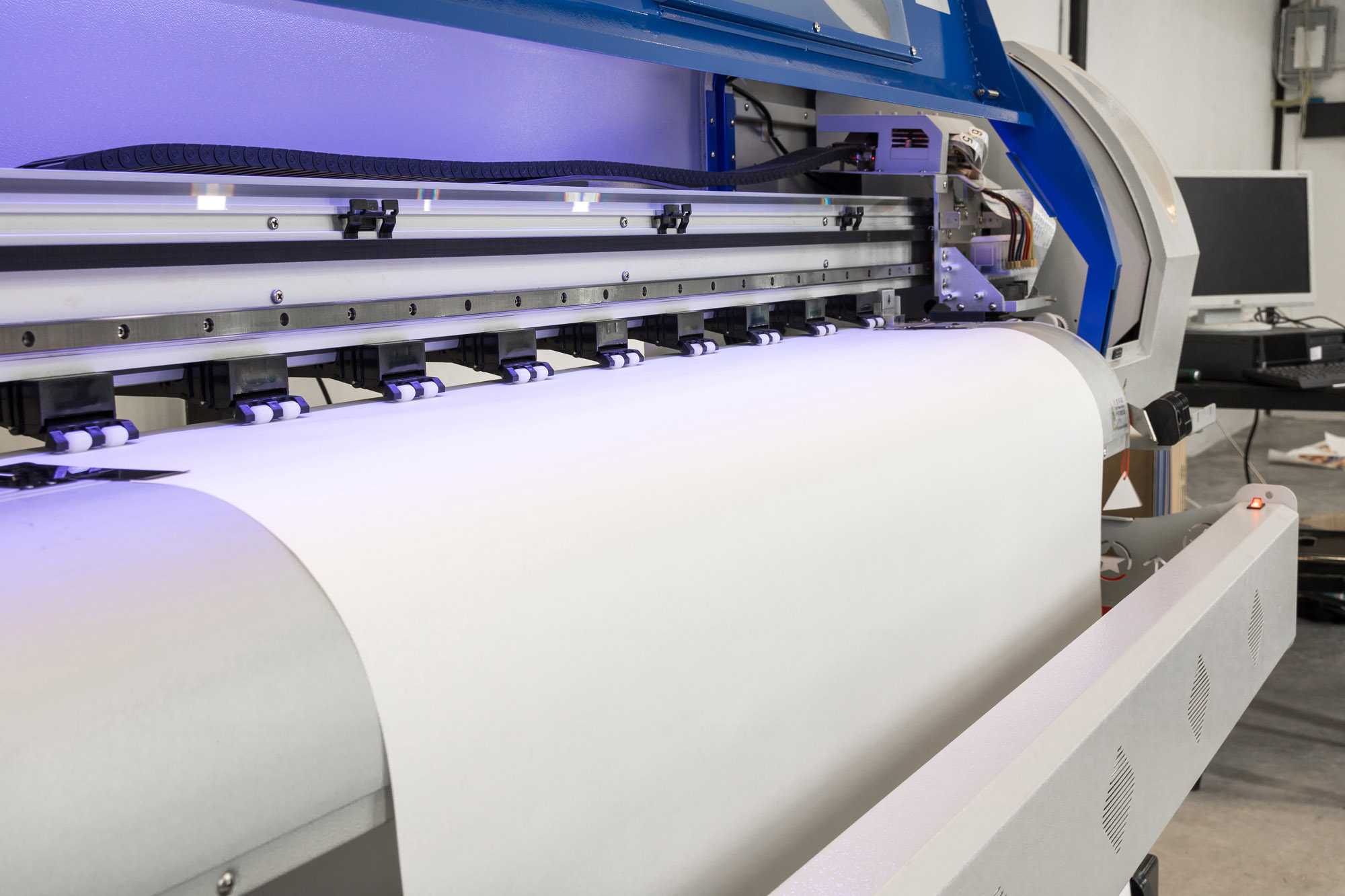 Blank paper roll in large printer format inkjet machine for industrial business.